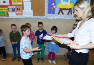 Kobieta wręcza chłopcu dyplom.