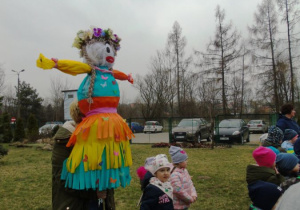 Kobieta trzyma kukłę marzanny.