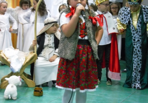 Dziewczyka w stroju góralskim śpiewa piosenkę. Za nią są pozostałe dzieci.