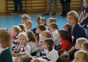 Na dywanie siedzą dzieci i oglądają przedstawienie.