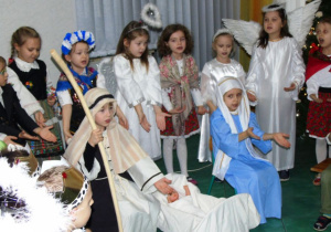 Maryja i Józef pomiędzy nimi Jezus w tle pasterze i aniołowie