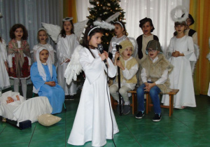 Dziewczynka w stroju anioła śpiewa