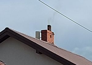 Dach z dymiącym kominem.