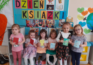Dziewczynki prezent5ują wykonane przez siebie prace.