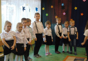 Dzieci stoją odświętnie ubrane