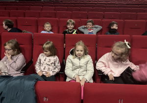 Grupa dzieci siedzi na widowni teatralnej