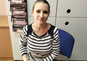 Na krzesełku siedzi pani która pozuje do zdjęcia