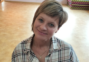 Na krzesełku siedzi pani która pozuje do zdjęcia