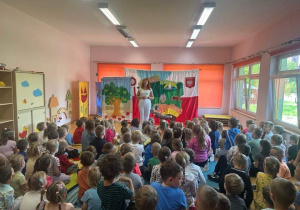 Pani przemawia do grupy dzieci.