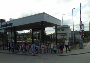 Dzieci wspólnie z nauczycielkami idą na peron stacji PKP.