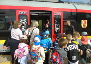 Dzieci wspólnie z nauczycielkami wchodzą do pociągu.
