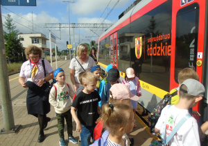 Dzieci wspólnie z nauczycielkami wchodzą do pociągu.