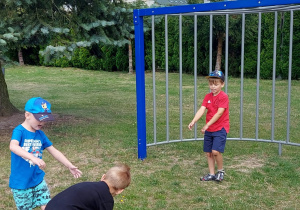 Chłopcy grają w piłkę na placu przedszkolnym.