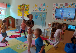 Dzieci tańczą w sali przedszkolnej.