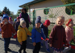 Grupa przedszkolaków wychodząca na spacer wraz z opiekunem