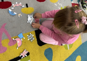 Dziewczynka dopasowująca papierowe ubranie dla Kici Koci