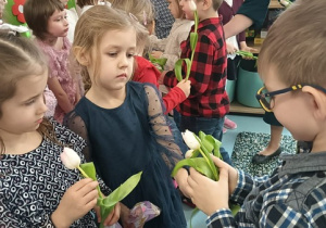 Chłopcy wręczający dziewczynkom tulipany