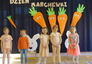 Grupa dziewczynek na tle dekoracji z okazji Dnia Marchewki