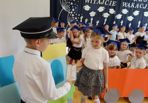 chłopiec daje dziewczynce papierowy (dekoracyjny) bilet