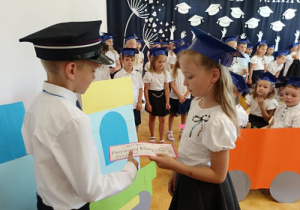 chłopiec i dziewczynka trzymają papierowy bilet (dekoracyjny)