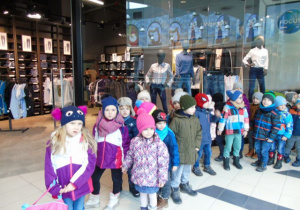 Dzieci stoją na pasażu Centrum Handlowego.