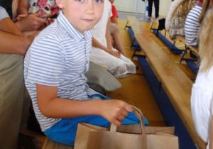 Chłopiec trzyma w rękach torbę z nagrodami