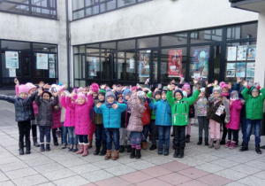 Dzieci stoją przed budynkiem.
