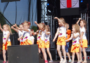 Dzieci tańczą na scenie.