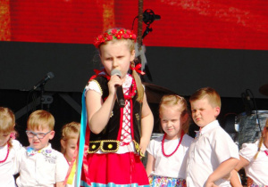 Dziewczynka w krakowski stroju śpiewa.