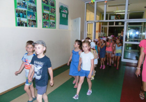 Grupa dzieci idzie korytarzem.