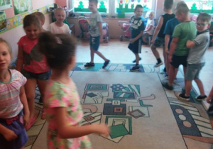 Grupa dzieci bawiących się na dywanie