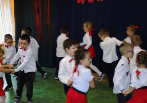 Dzieci tańczą w parach po obwodzie koła.