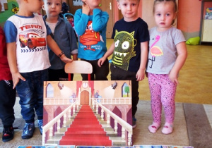 Pięcioro dzieci stoi, przed nimi makieta zamku.