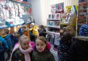Dzieci chodzą w budynku Poczty Polskiej.