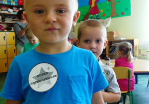 Chłopiec w niebieskiej koszulce z napisem Super przedszkolak.