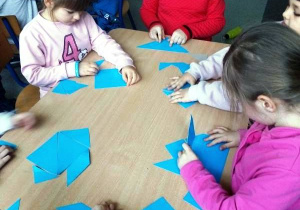Dzieci układają niebieskie figury.
