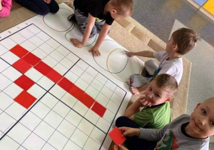 Dzieci kodują na dywanie.