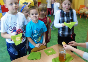 Dzieci trzymają w rękach wafle z miodem