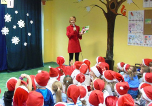 Kobieta w czerwonym stroju mówi do mikrofonu