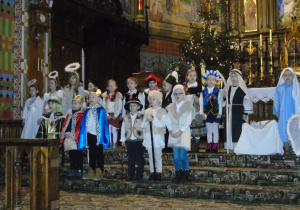 Dzieci w kościele stoją na schodkach