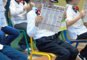 Chłopcy w kapeluszach czytają gazety