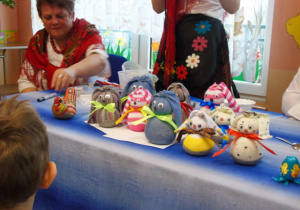 Na niebieskim stole stoją króliczki wykonane przez dzieci z przedszkola