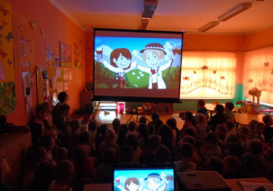 Dzieci oglądają patriotyczny film na dużym ekrenie w ciemnej sali