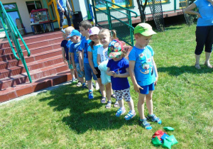 Dzieci w niebieskich koszulkach stoją w rzędzie