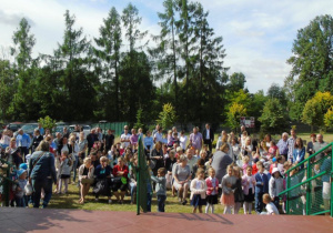 Tłum zgromadzonych ludzi w ogrodzie przedszkolnym