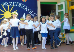 Dzieci odśiętnie ubrane tańczą Poloneza