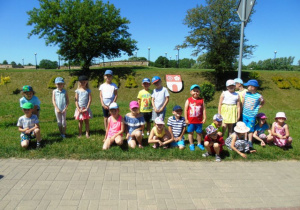 Grupa dzieci na zielonej trawie za nimi hebr gminy Gorzkowice